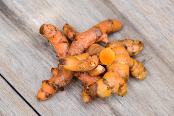 Turmeric rhizome on an old wooden background.