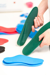 Orthopedic insole. The orthopedist works with the patient. Orthopedic clinic. Choice of insoles in an orthopedic clinic. The orthopedist offers the insole to the patient Foot care