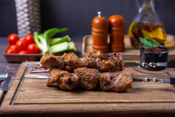 Traditional Russian shashlik on skewers with vegetables. Grilled pork meat (shish kebab). Close-up.