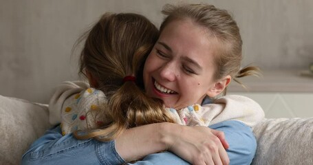 Cheerful missed mother cuddling tightly her little 8s loving daughter after long separation enjoy reunion, feeling love, showing candid emotions, close up view. Happy motherhood, family bond concept