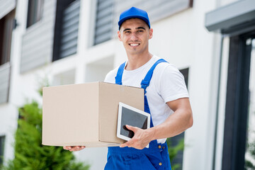 Young delivery man hold a cardboard box in his hands