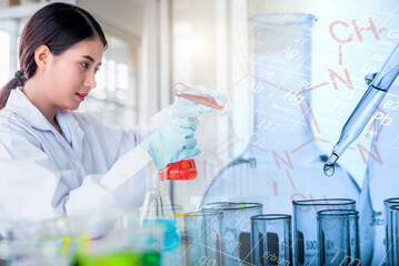 Attractive scientist woman looking chemical sample in flask at laboratory with lab glassware...