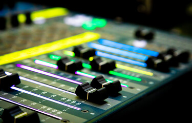 Sliders and buttons on Audio Mixing Desk at live event.
