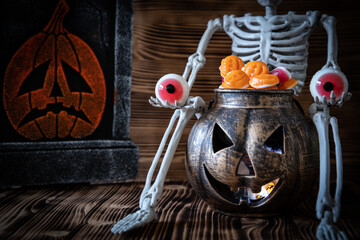 Ein Gerippe zu Halloween, welches einen Kürbis und Süßigkeiten dabei hat und gruselig ist