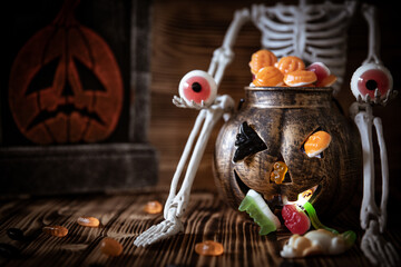 Ein Gerippe zu Halloween, welches einen Kürbis und Süßigkeiten dabei hat und gruselig ist
