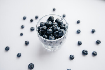 Beautiful ripe blueberries in a transparent glass glass on a white background. Healthy food, and vitamins.