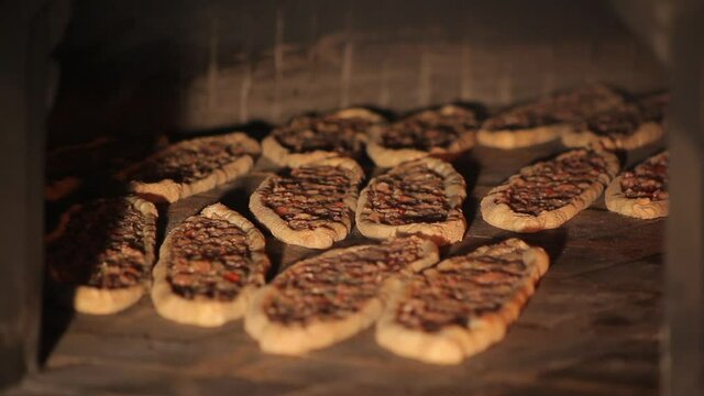 Pides cooked in wood fire. Turkish pizza. Pita with mince. Crispy dough. Hot oven.