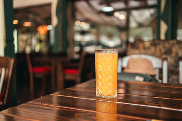 Fresh ice orange juice glass on wood table in a cafe. Diet concept