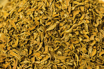 Turmeric rhizomes dried slices on nature background.