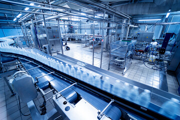 Conveyor belt with bottles of drinking water at a modern beverage plant.