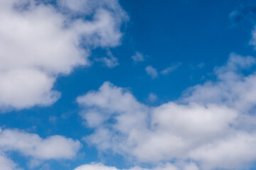 Weiße Wolken vor blauen Himmel an einem sonnigen Tag