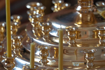 Extinguished candles on the background of a golden candlestick in the Orthodox church. The interior...