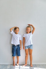 Little girl and boy measuring their height
