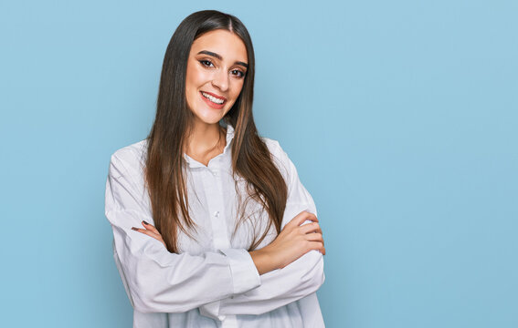 Young beautiful woman wearing casual white shirt happy face smiling with crossed arms looking at the camera. positive person.