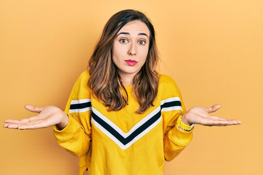 Young hispanic girl wearing casual clothes clueless and confused with open arms, no idea concept.