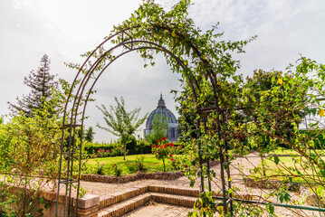 View of the dome of Saint Peter's Basilica in Rome seen from a garden