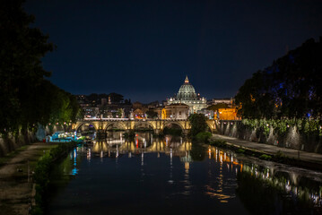 Fototapeta na wymiar View of the dome of Saint Peter at night together with the Tiber river