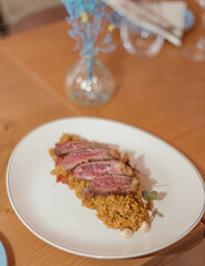 Plato gourmet de  delicados cortes de ternera sobre un exquisito arroz especiado