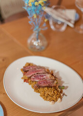 Plato gourmet de  delicados cortes de ternera sobre un exquisito arroz especiado