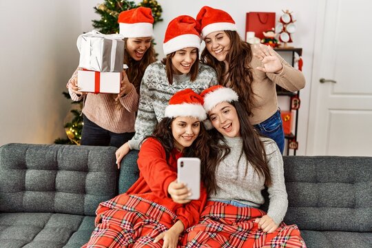 Group of young hispanic women on christmas meeting make selfie by the smartphone at home.