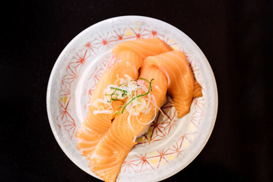 Sushi and Sashimi. Dishes of Sushi and Sashimi rolling on conveyer belt.