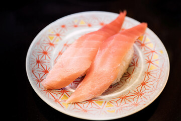 Sushi and Sashimi. Dishes of Sushi and Sashimi rolling on conveyer belt.