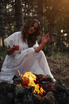 Beautiful mystery gothic woman in long white dress in autumn forest.