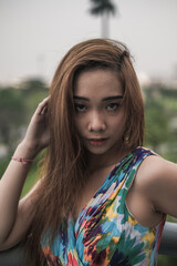 Fototapeta premium Close-up portrait of beautiful asian woman outdoor. Wind in her hair. Beautiful sunlight. High quality photo 