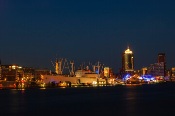 Fototapeta na wymiar Hamburg skyline long exposure with river Elbe and ship illuminated after sunset | Hamburg, Germany
