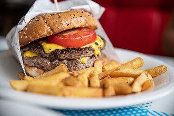 Delicious burgers with beef, tomato, lettuce and fries served at restaurant.