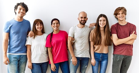 Group of young friends standing together over isolated background with a happy and cool smile on...