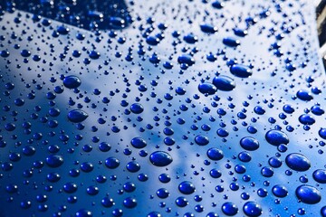 Raindrops on a blue car body with hydrophobic effect. - obrazy, fototapety, plakaty