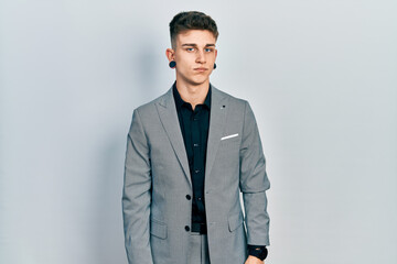 Fototapeta premium Young caucasian boy with ears dilation wearing business jacket looking sleepy and tired, exhausted for fatigue and hangover, lazy eyes in the morning.