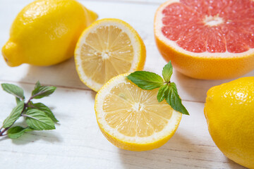 Fototapeta na wymiar lemons and grapefruit on white wooden background