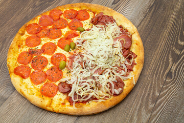View from above peperoni and calabrian pizza, on wooden table.