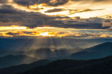 Sunset sky with sun rays over the mountains