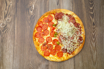 Big pizza with top view. Peperoni flavor. On a wooden table.