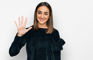 Beautiful brunette woman wearing elegant sweater showing and pointing up with fingers number five while smiling confident and happy.