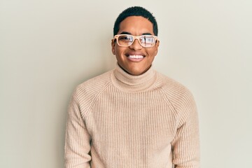 Obraz premium Young handsome hispanic man wearing turtleneck neck sweater and glasses with a happy and cool smile on face. lucky person.