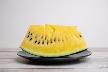 Yellow watermelon on black plate, think different