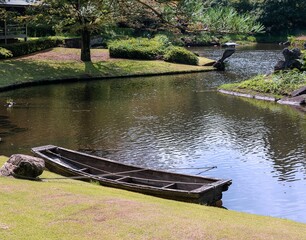 日本庭園の池に浮かぶ船（夏の風景）