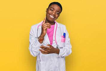 Young african american woman wearing doctor uniform and stethoscope with a big smile on face, pointing with hand and finger to the side looking at the camera.