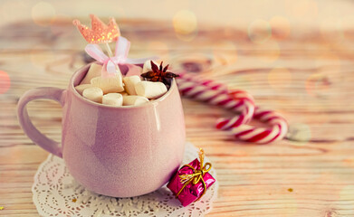 Christmas drink background, pink cup with hot chocolate and marshmallows on a wooden table near New Year's decor. Cocoa Christmas drink, copy space, bokeh effect, drink mug Christmas holiday 