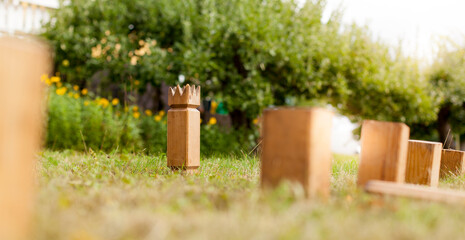 Wikingerschach (Kubb) aus Holz in Garten aufgestellt. Wooden Kubb sticks in garden. Wooden Kubb game.