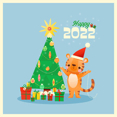 A baby tiger wearing a Santa hat is decorating a Christmas tree.  There are toys and garlands hanging on the tree.   There are boxes with gifts under the tree. Above is the text "happy 2022". 
