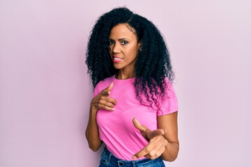 Middle age african american woman wearing casual clothes pointing fingers to camera with happy and funny face. good energy and vibes.