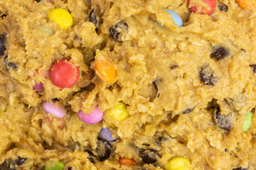 background of chocolate chip cookie dough with colorful chocolate candy