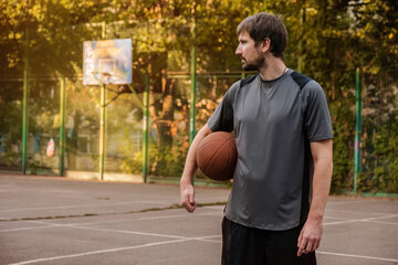 Basketball player with ball on an outdoor basketball court. Active lifestyle concept