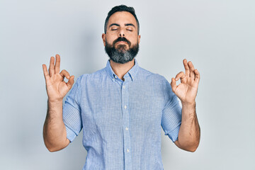 Young hispanic man wearing casual clothes relax and smiling with eyes closed doing meditation gesture with fingers. yoga concept.