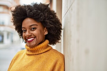 Fototapeta premium Young african american girl smiling happy standing at the city.